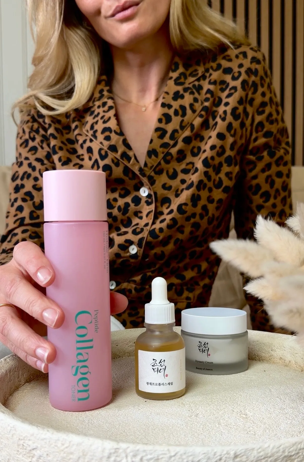 Mise en scène produit : soin en flacon, sérum et crème sur pouf